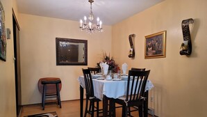 A dining area with a round table, chairs, a chandelier, a mirror, and wall decorations. - Stylish two bedroom Condo (Milwaukee)