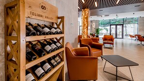 A modern interior with a wine rack labeled "TELIANI VALLEY" and leather seating. - Kutaisi Inn (Kutaisi)