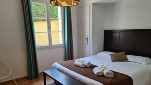 A neatly arranged bedroom with a bed, bedside table, and a window with curtains. - Villa Provencale Avec Piscine Privee (Sainte-Maxime)