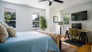 A bedroom with a bed, a desk, a chair, a TV, and a ceiling fan. - Updated near beach home, outdoor paradise, sleeps 6! (Isle of Palms)
