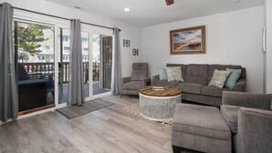 A modern living room with a sofa, armchairs, a coffee table, and a ceiling fan. - Large Ocean City Waterfront Townhome w/ Boat Slip (Ocean City)