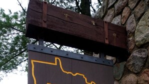A wooden sign with the text "Itasca State Park" outlined in yellow. - {Big Timbers} Lodging next to North Entrance of Itasca State Park (Shevlin)