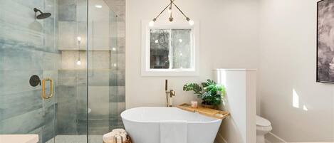 Een bad/douchecombinatie, een haardroger, handdoeken, zeep