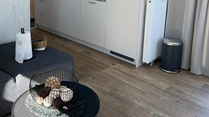 A compact kitchen with a gas stove, microwave, and white cabinets.