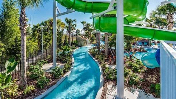 A water park with multiple slides, a winding pool, and palm trees. - 🌺 Aloha Oasis | Private Pool • Windsor Island • Near Disney (Davenport)