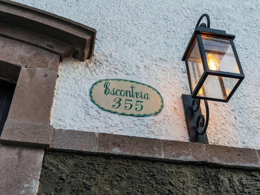 Fachada de un edificio con una farola y un cartel que dice "Escontria 355".