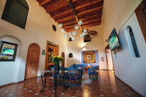 A spacious lobby with a high ceiling, tiled floor, and blue upholstered seating. - Hotel Casa Tequis San Luis Potosi (San Luis Potosi)