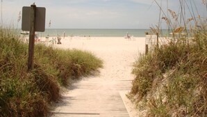 A sandy beach path leading to a beach with a signpost. - Midnight Cove #714, Bayside in Siesta Key, FL, 2BR-1 1/2BA, 1st Floor (Sarasota)