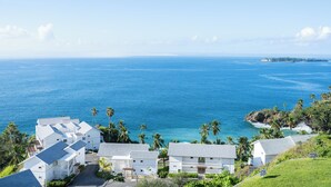 A coastal view with white buildings, palm trees, and a clear blue sea. - Perfect Paradise, Oceanview Samana #PRIVATEBEACH#OCEANVIEW#PARKING#STARLINK#AC (Samana)