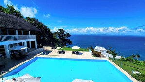 A pool area with umbrellas and lounge chairs, overlooking a scenic ocean view. - Perfect Paradise, Oceanview Samana #PRIVATEBEACH#OCEANVIEW#PARKING#STARLINK#AC (Samana)