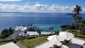 A coastal property with a view of the ocean, white buildings, and a patio with umbrellas. - Perfect Paradise, Oceanview Samana #PRIVATEBEACH#OCEANVIEW#PARKING#STARLINK#AC (Samana)