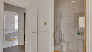 A bathroom with a bathtub, toilet, and shower.