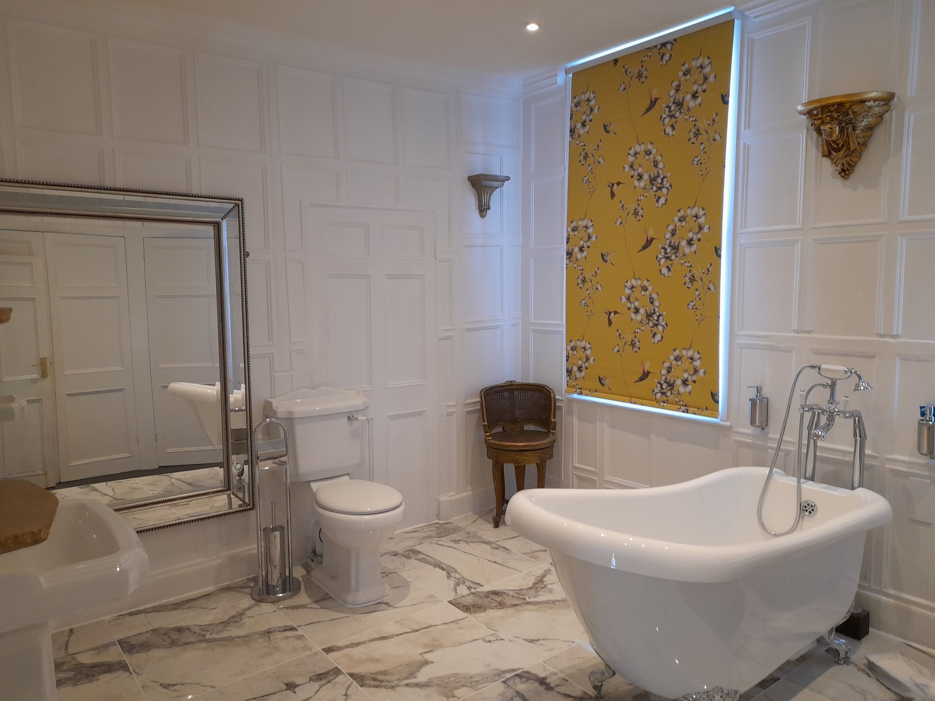 A bathroom with a freestanding bathtub, a toilet, and a shower area.