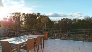 An outdoor patio with a glass table and chairs, surrounded by a metal railing and a view of trees and sky. - VILLA WITH HEATED SWIMMING POOL JACCUZI SAUNA (Barjac)