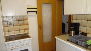 Eine Küche mit Herd, Backofen und Kaffeemaschine.