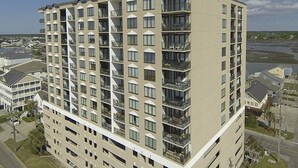 Un hôtel à plusieurs étages doté d’une architecture moderne, avec des balcons à chaque niveau et un toit plat.