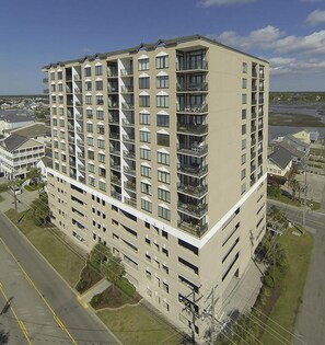 A multi-story hotel with a modern architectural design, featuring balconies on each floor and a flat roof. - Beach Walk Villas 908 -2BR-Cherry Grove-I/O Pools (North Myrtle Beach)