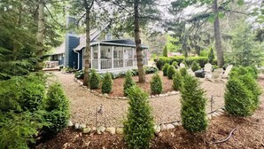 A house surrounded by a forest with a gravel path leading to a porch. - 1min to Private Beach, High-end Design & Hot tub (New Buffalo)
