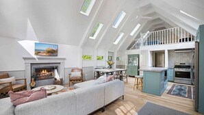 A spacious loft with a high ceiling, a fireplace, a dining area, and a kitchen. - 1min to Private Beach, High-end Design & Hot tub (New Buffalo)