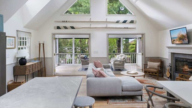 A spacious room with a high ceiling, large windows, a fireplace, and a balcony. - 1min to Private Beach, High-end Design & Hot tub (New Buffalo)