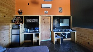 A room with two wooden desks, a Harley-Davidson sign, a refrigerator, and a blackboard. - Harley-Davidson Cabana at Tipsy Toad Retreat (Boyd)