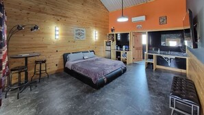 A cozy room with a bed, a small table, and a bar area. - Harley-Davidson Cabana at Tipsy Toad Retreat (Boyd)