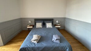 Ein Schlafzimmer mit einem Bett, zwei Nachttischen und einer Nachttischlampe auf jeder Seite.