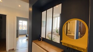 Ein modernes Badezimmer mit dunkler Wand, einem Holzwaschtisch, einem Spiegel und Blick ins Freie.