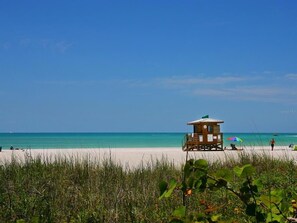 A beach with a lifeguard tower, clear turquoise water, and a sandy shore. - ★ New Luxury Waterfront Condo ★ Pool/Gym/Hot tub ★ (Sarasota)