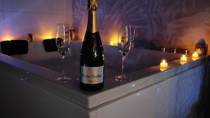 Eine Bar mit einer Nicolas Feuillatte Champagnerflasche, zwei Gläsern und Kerzen.