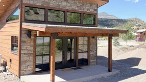 Un bâtiment moderne à deux étages, doté d’une façade en pierre, de grandes fenêtres et d’une entrée abritée.