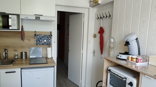 A compact kitchen with a microwave, toaster, and coffee maker on the counter. - Logement Entier : Logement de Vacances Chez Christian (La Bourboule)