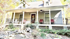 A two-story house with a covered porch, a small attic window, and a front door.