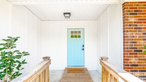 A wooden staircase leading to a blue door with a welcome mat. - Spacious w/ all King Beds, 15 min from Beach + Downtown, Pup Friendly! (Wilmington)