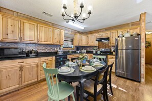 Enjoy cooking in this well-equipped kitchen with a central island, oven, and stainless steel refrigerator.