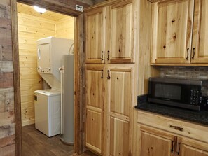 Compact kitchen with microwave, refrigerator, and washing machine.
