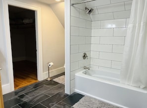 Bañera con ducha, toallas, jabón, shampoo
