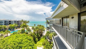 A hotel with a pool, lush greenery, and a view of the ocean. - Top floor amazing view Toms Chicken Coop awaits your next stay. Best value (Key West)