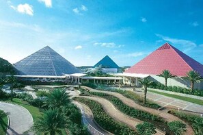 A large complex with multiple pyramid-shaped buildings, a central walkway, and surrounding greenery.