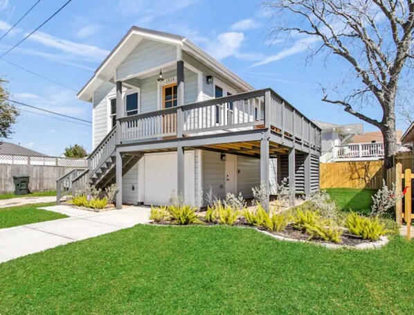 A two-story house with a covered front porch, a garage, and a well-maintained lawn.