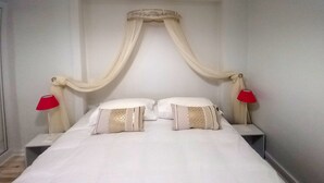 A bed with a canopy, two bedside tables, and two red lamps. - APARTMENT FACING FONCILLON BEACH (Royan)