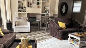 A living room with a fireplace, a ceiling fan, and a dining area with a table and chairs. - 5 Miles from Hayward field (Eugene)