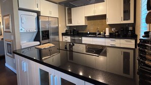 A modern kitchen with stainless steel appliances, a glass island, and white cabinetry. - Well Appointed fully furnished 2BR, 2Bath, 1st floor, Guard-Gated, Biltmore area (Phoenix)