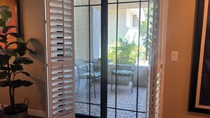 A room with a sliding glass door leading to an outdoor patio area with a table and chairs. - Well Appointed fully furnished 2BR, 2Bath, 1st floor, Guard-Gated, Biltmore area (Phoenix)