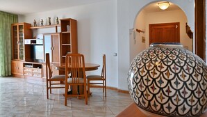 A dining area with a table and chairs, a cabinet with drawers, and a patterned vase on a table. - 1st Line Sea View · Plaza Terrace (Santiago del Teide)