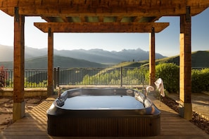 Ein Whirlpool unter einer Holz-Pergola mit Blick auf die Berge.