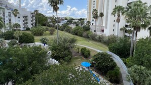 Un hôtel à étages, doté d’une pelouse bien entretenue et de plusieurs palmiers.