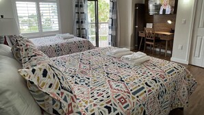 Une chambre d’hôtel avec deux lits, un bureau et une télévision.
