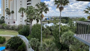 Un hôtel au design moderne, doté d’un espace piscine agrémenté de palmiers et offrant une vue sur un lac.