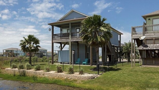 Una casa frente al mar de dos plantas con balcón, piscina pequeña y vista al océano.